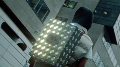 a man walking down a street holding a box