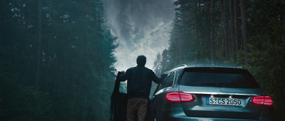 a man standing next to a car on a road