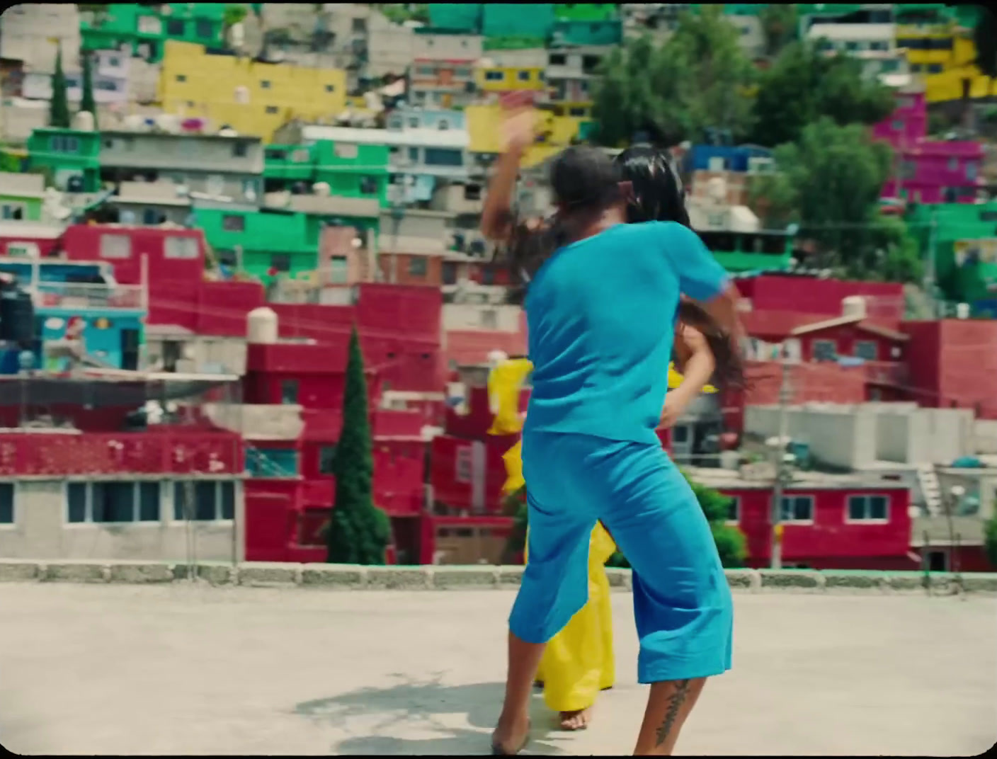 a woman in a blue jumpsuit is throwing a frisbee