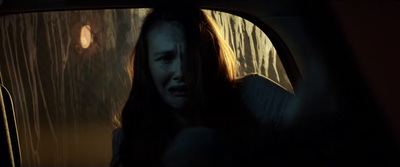 a woman sitting in a car in the rain