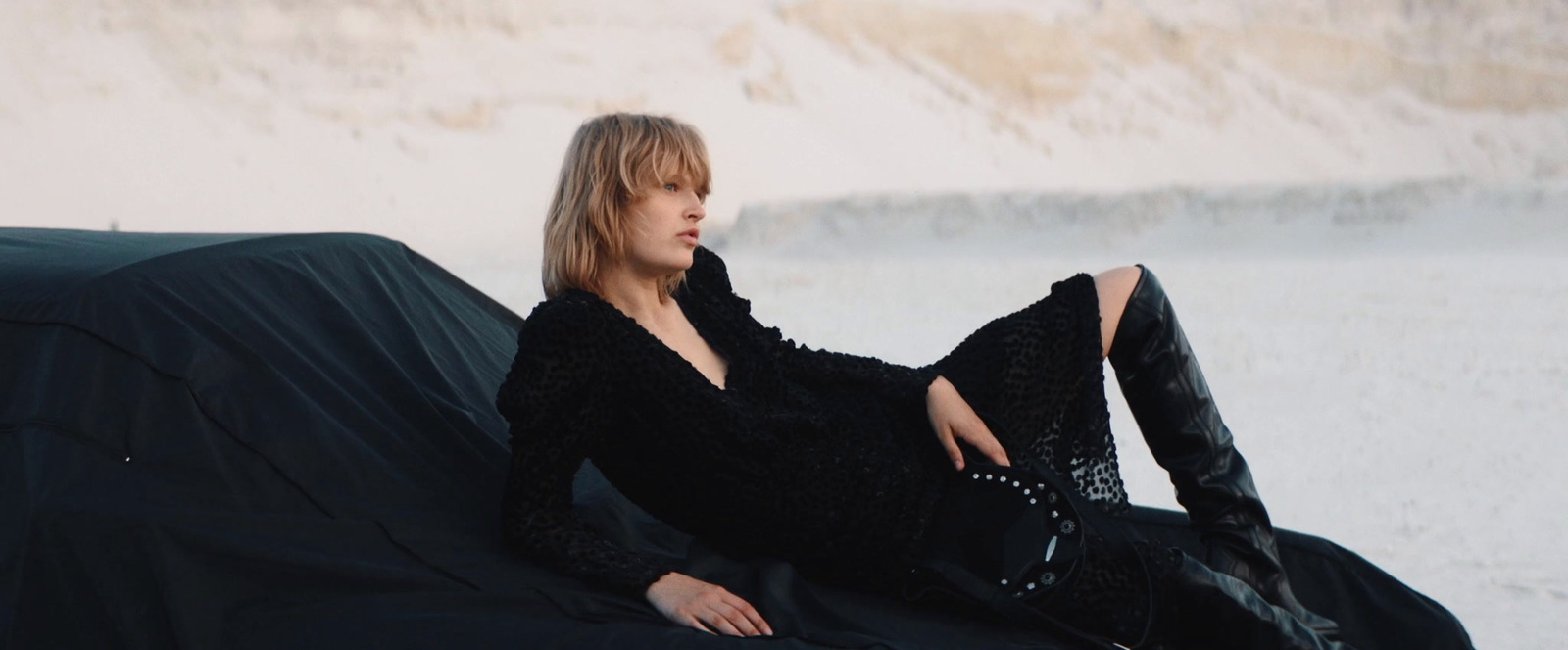 a woman sitting on top of a black couch