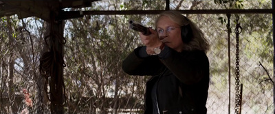 a woman holding a gun while wearing headphones