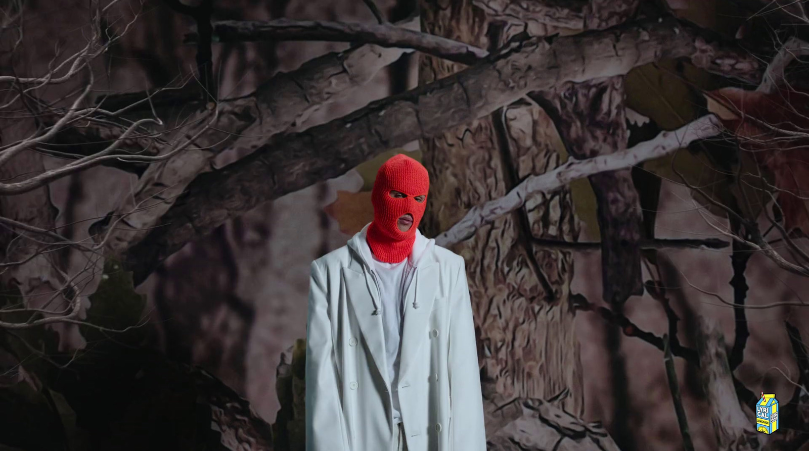 a man wearing a red mask standing in front of a tree