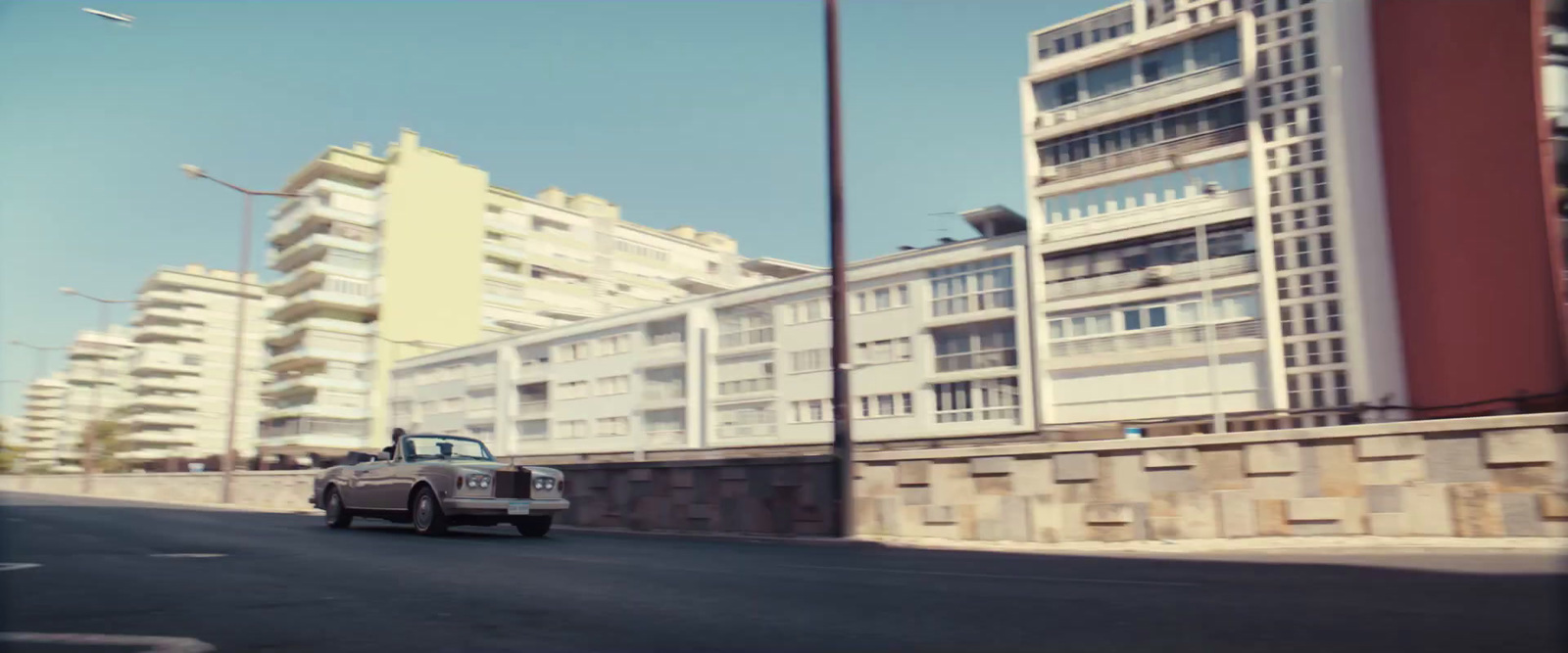 a car driving down a street next to tall buildings