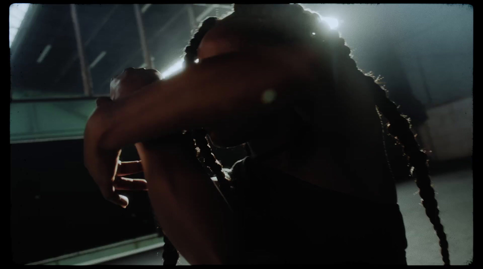 a man with dreadlocks standing in a dark room