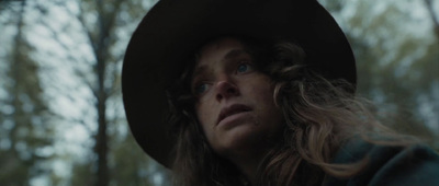 a woman wearing a hat in the woods