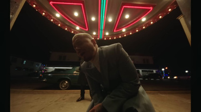 a man standing in front of a neon sign