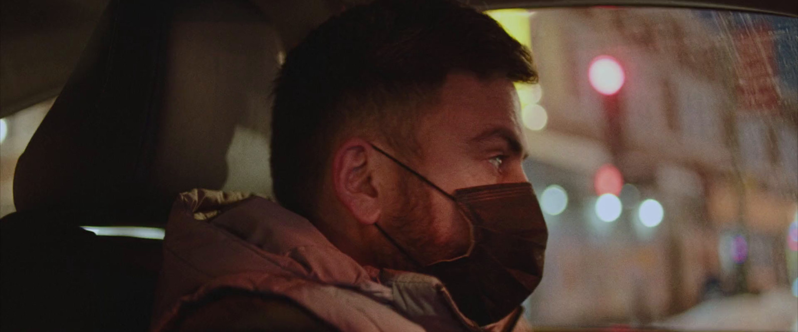 a man in a car wearing a face mask