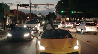 a group of cars driving down a street at night