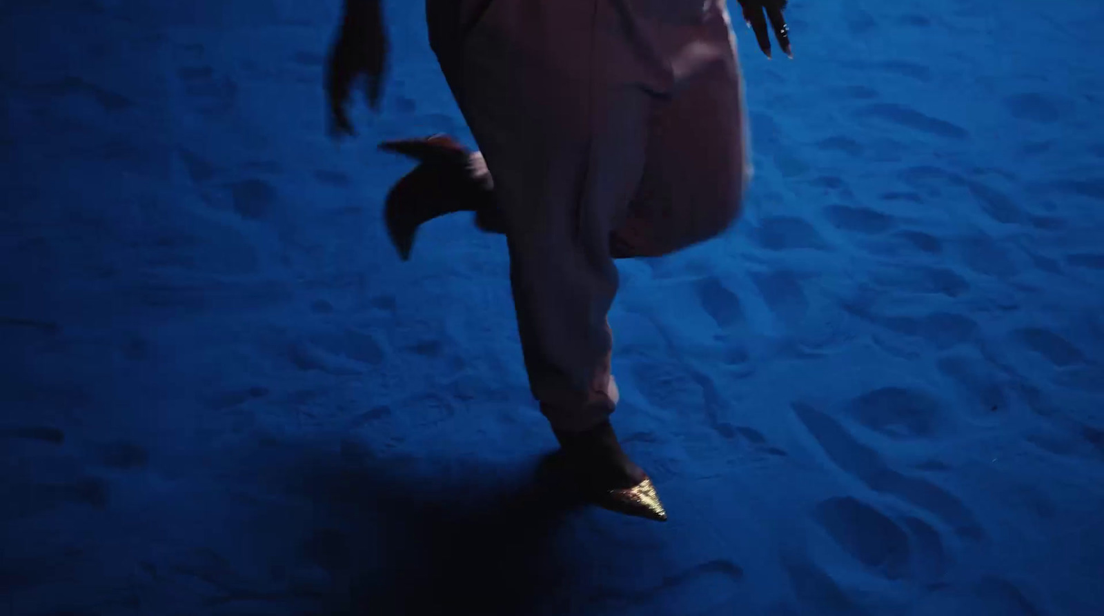 a man in a costume is running through the sand