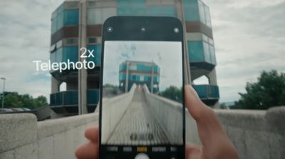 a person holding a cell phone taking a picture of a building