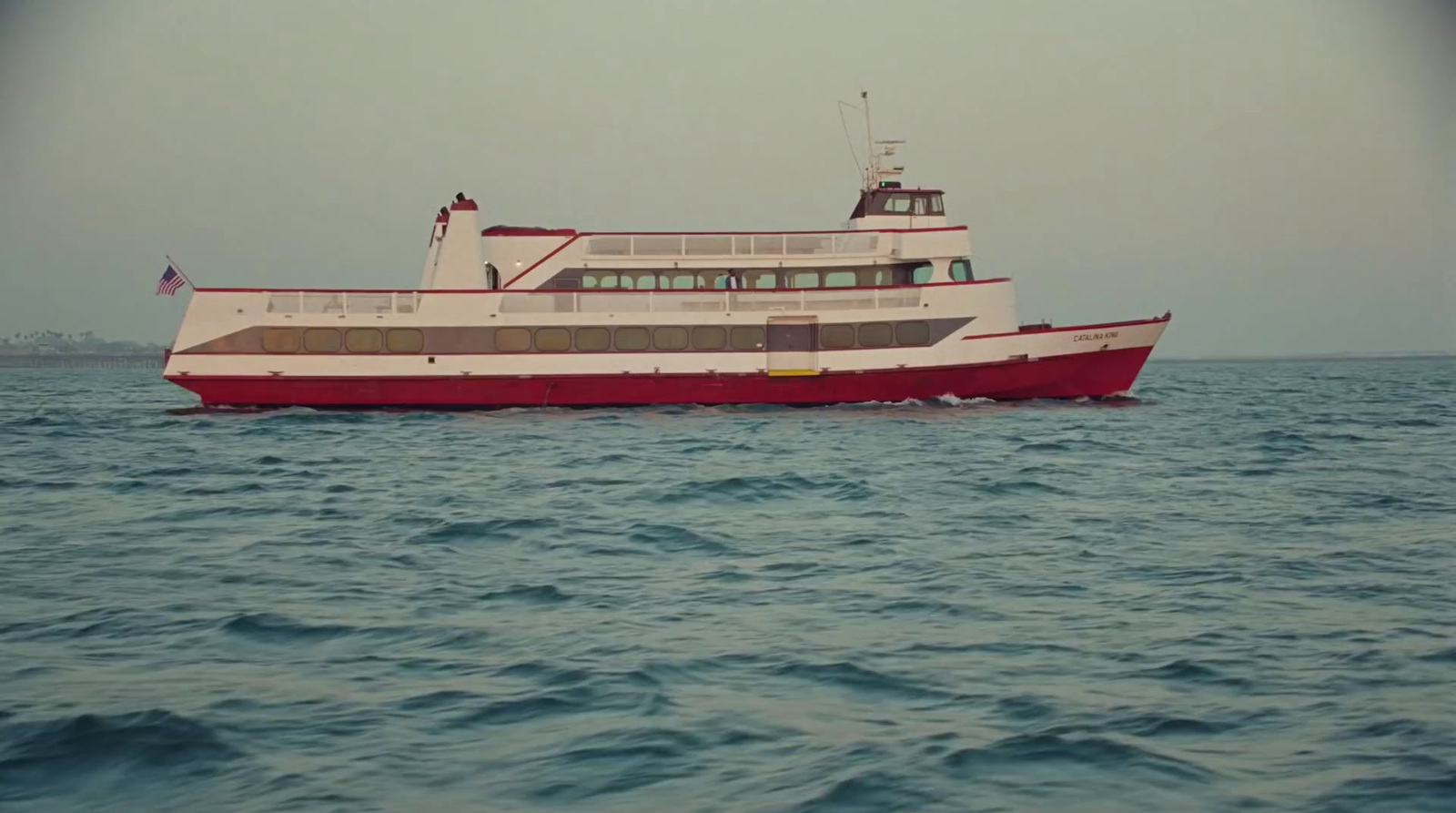 a red and white boat in the middle of the ocean