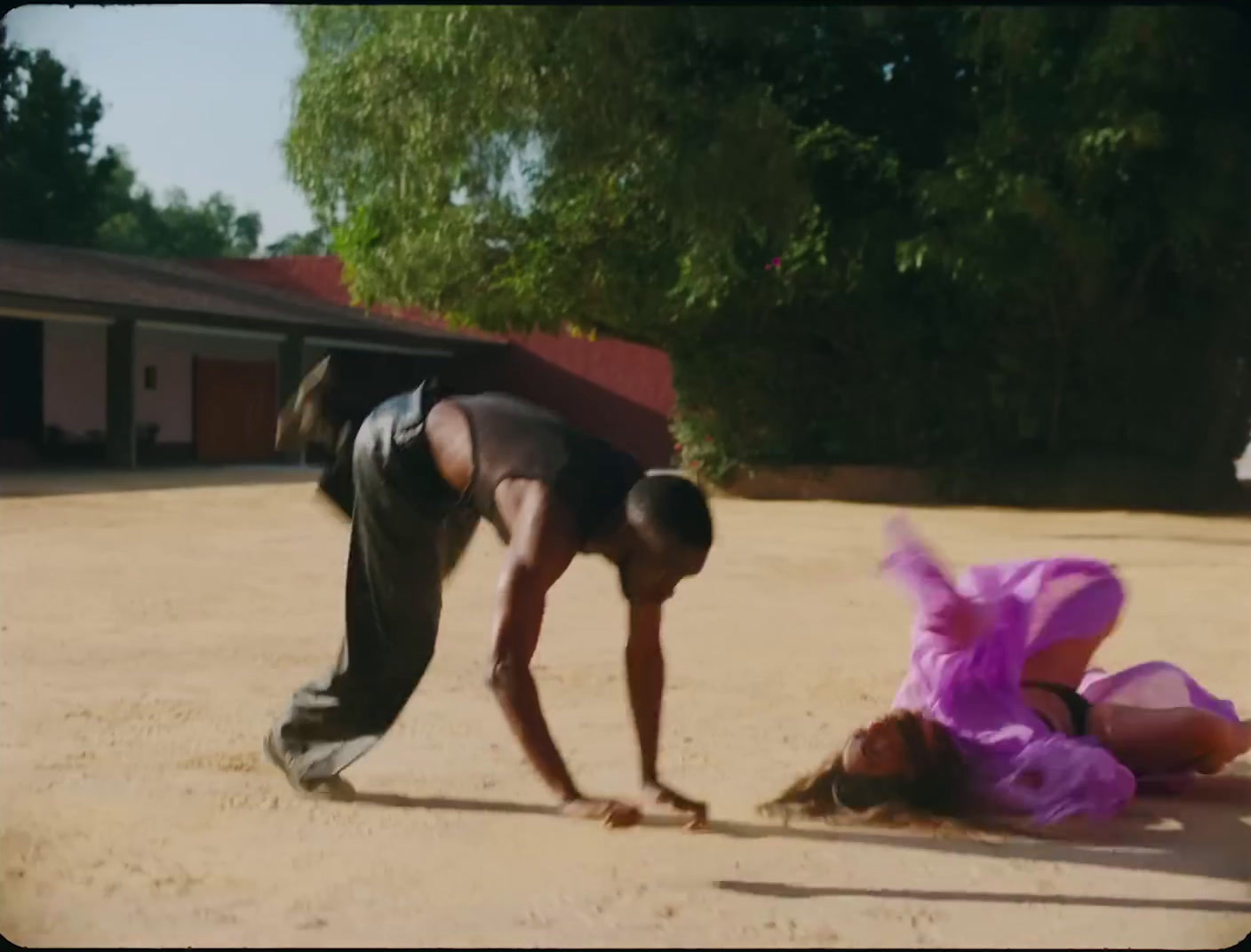 a man bending over to pick up a woman on the ground