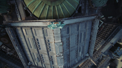 an aerial view of a tall building with a green roof