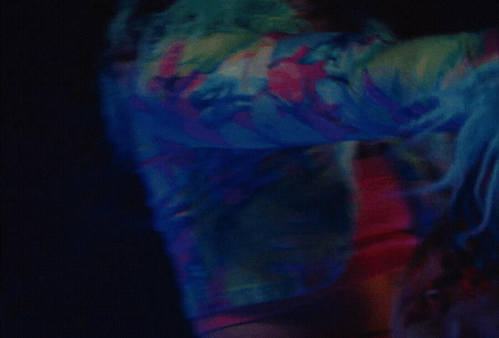 a blurry image of a person wearing a tie dye shirt