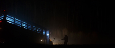 a man standing in the dark holding a broom