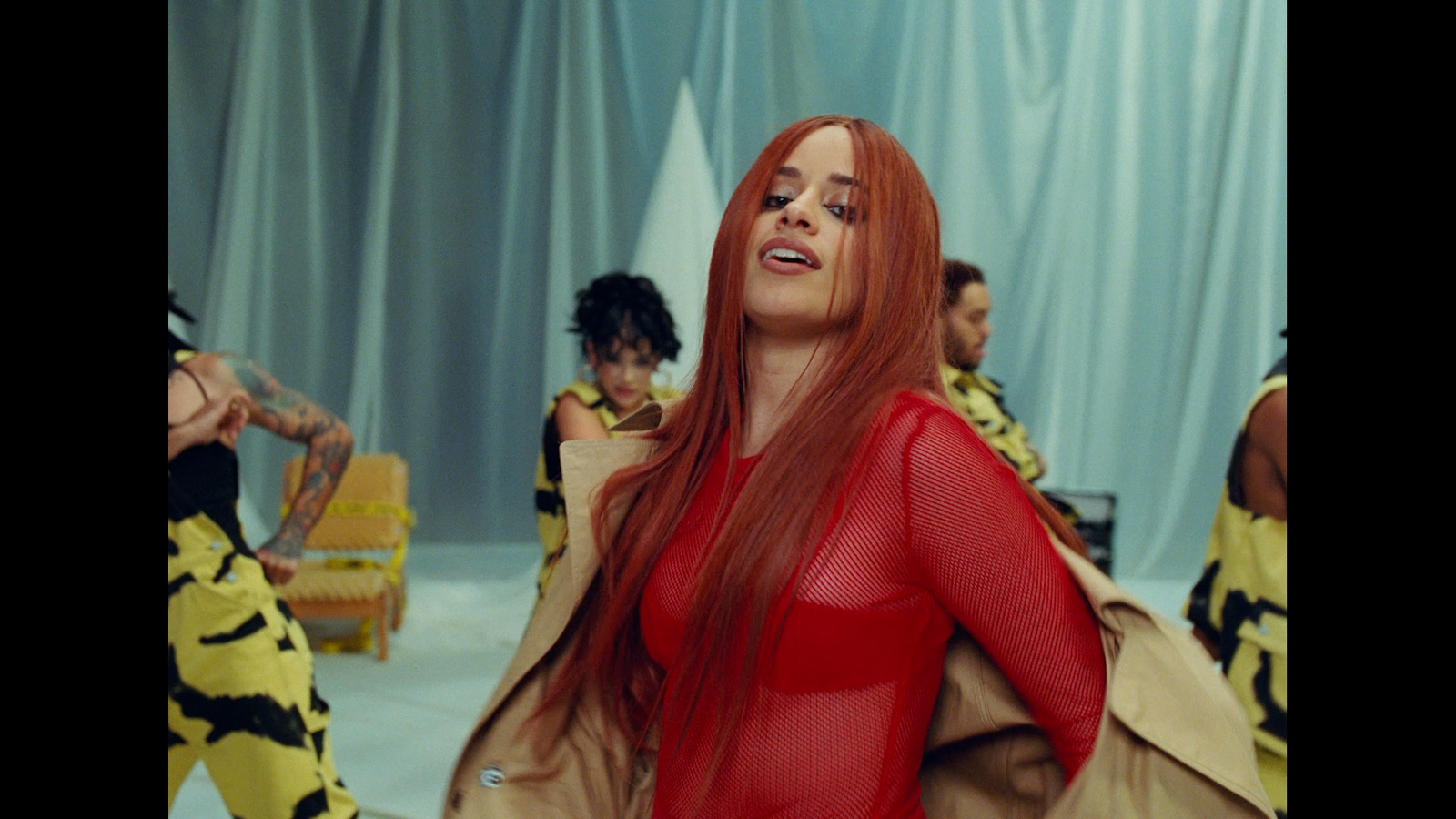 a woman in a red bodysuit standing in front of a group of people