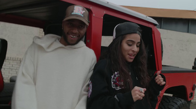 a man and a woman standing in the back of a red truck