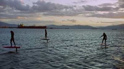 a group of people riding surfboards on top of a body of water