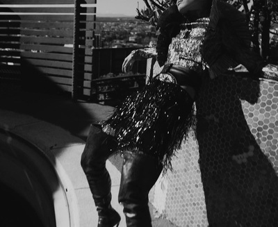 a woman standing on top of a building next to a tree