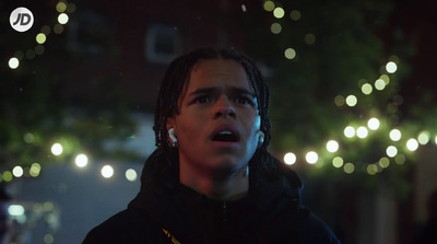 a man with dreadlocks standing in the dark