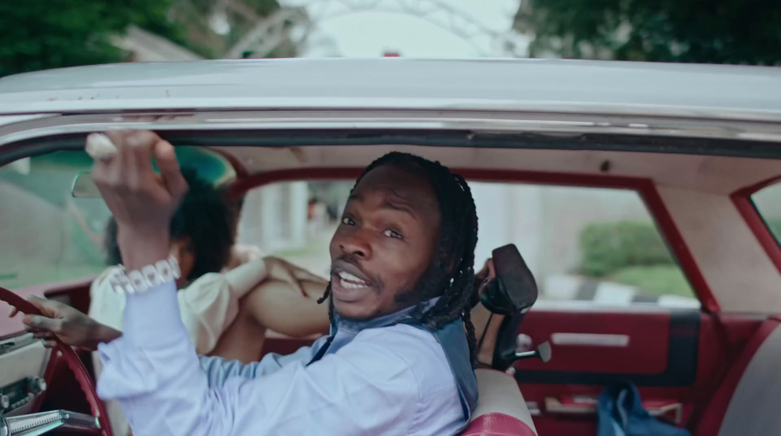 a man driving a car with a woman in the back seat