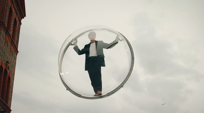 a man in a suit and tie standing on a circular object