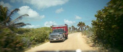 a truck is driving down a dirt road