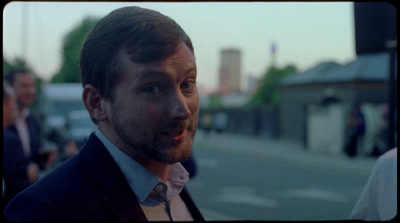 a man in a suit and tie standing on a street