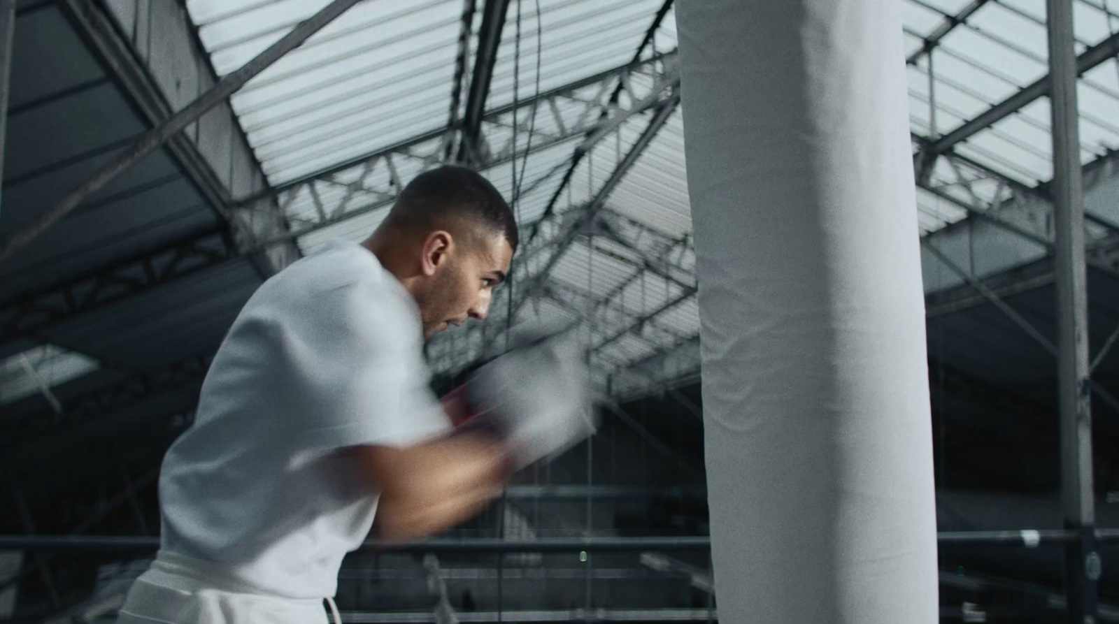 a man in a white shirt hitting a punching bag