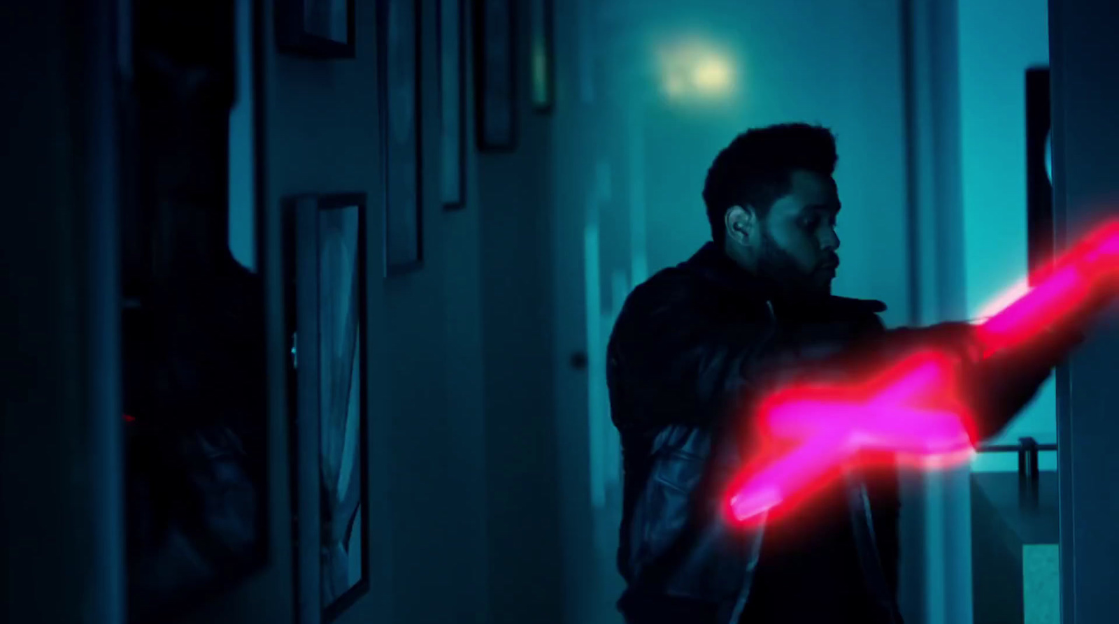 a man in a dark room holding a red light saber