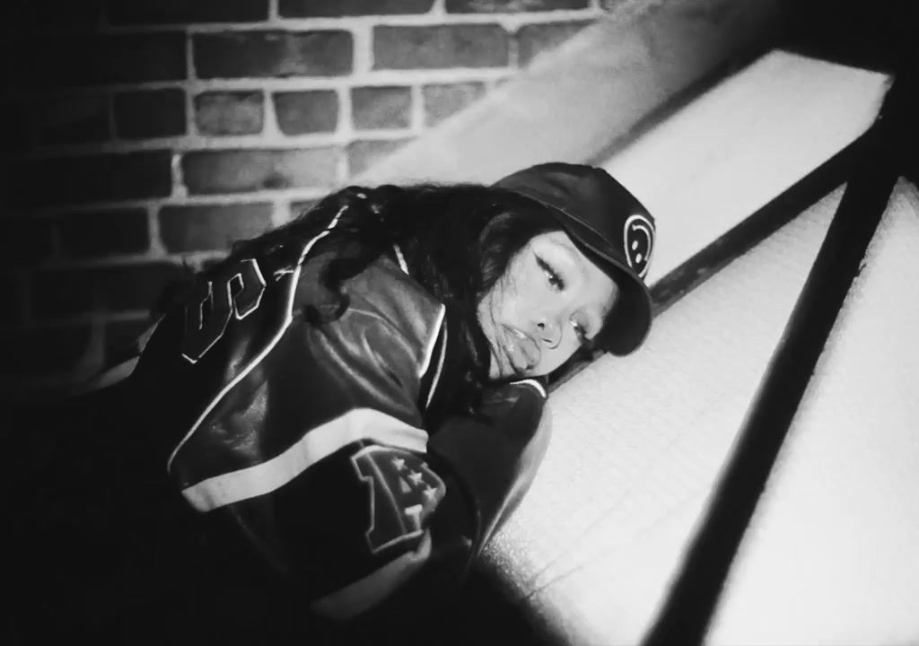 a young man wearing a leather jacket and hat