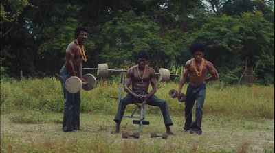 a group of three men standing next to each other in a field