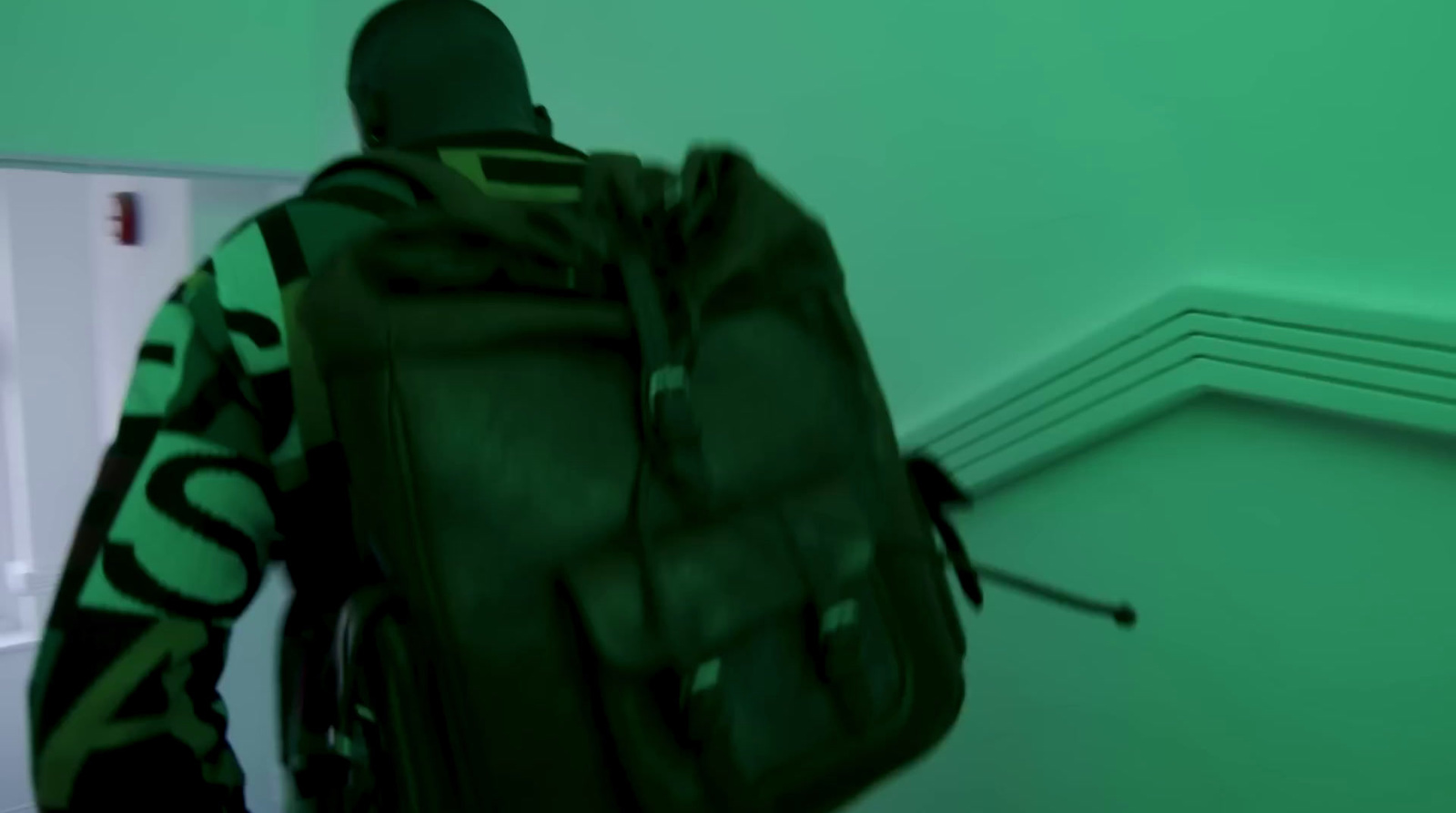 a man with a backpack walking down a hallway