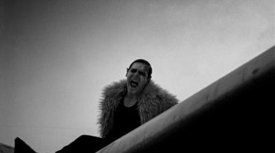 a man in a fur coat sitting on a ledge