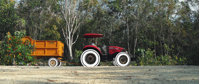 a red tractor pulling a yellow trailer behind it