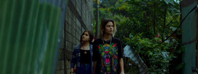 two women walking down a narrow alley way