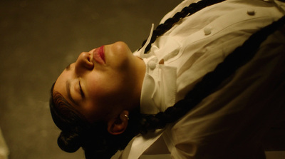 a woman with her eyes closed wearing a white shirt