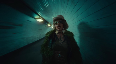 a woman wearing a fur coat and sunglasses in a tunnel