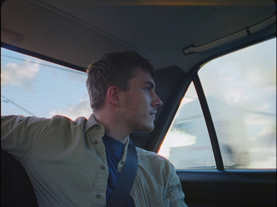 a man sitting in a car wearing a tie