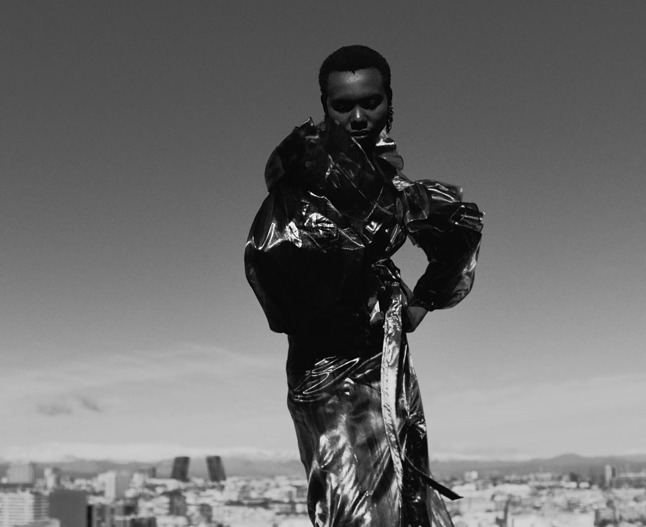 a black and white photo of a man in a shiny dress