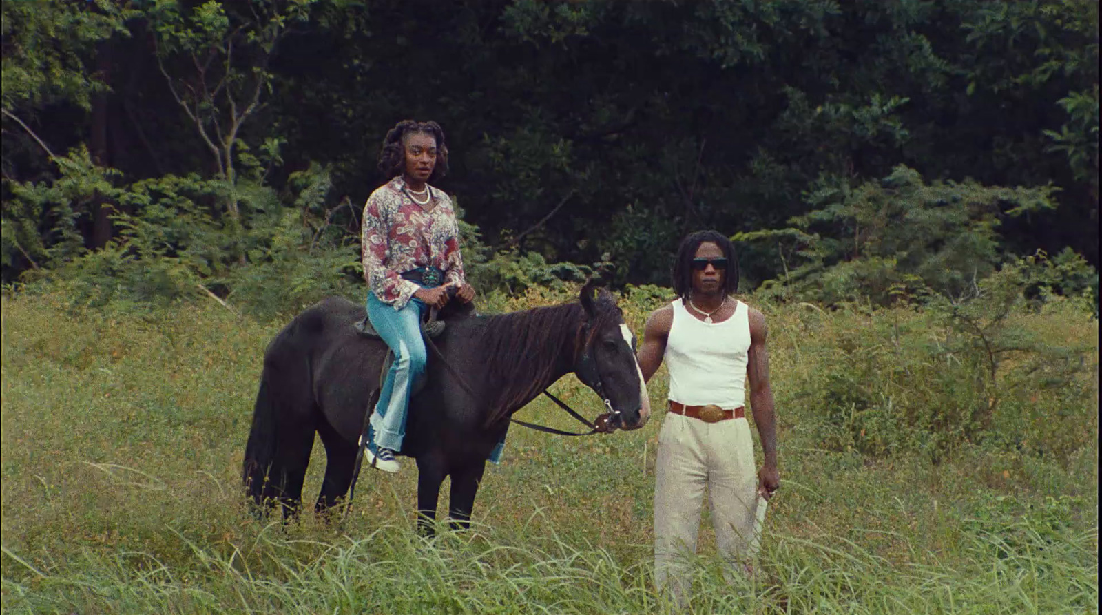 a man and a woman riding on the back of a black horse