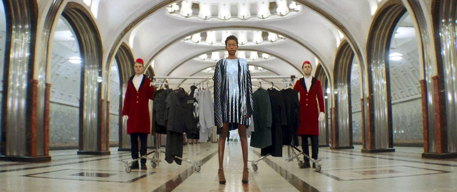 a woman standing in front of a row of mannequins