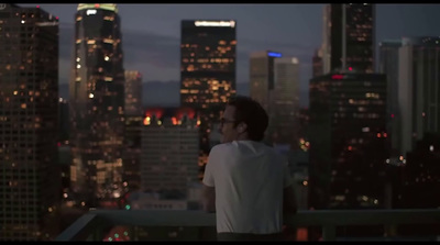 a man standing on top of a roof looking at the city