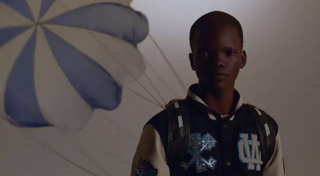 a man standing in front of a blue and white parachute