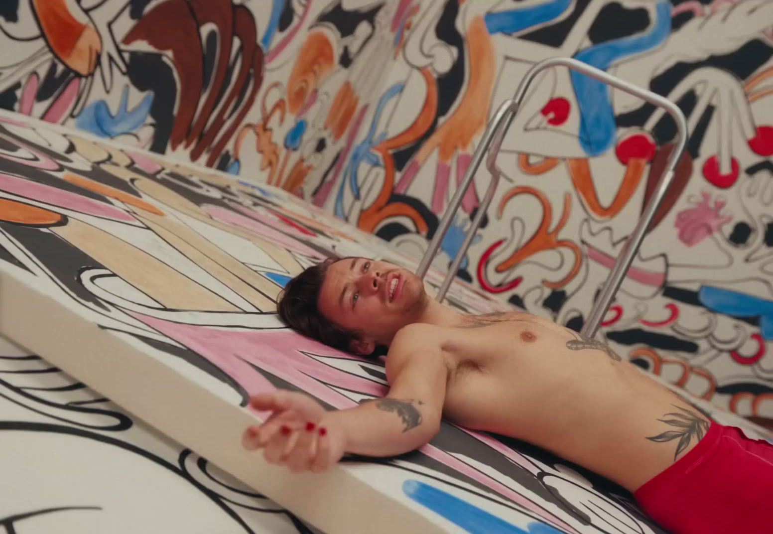 a man laying on top of a bed covered in graffiti