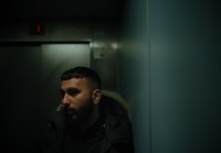 a man with a beard standing in a dark room