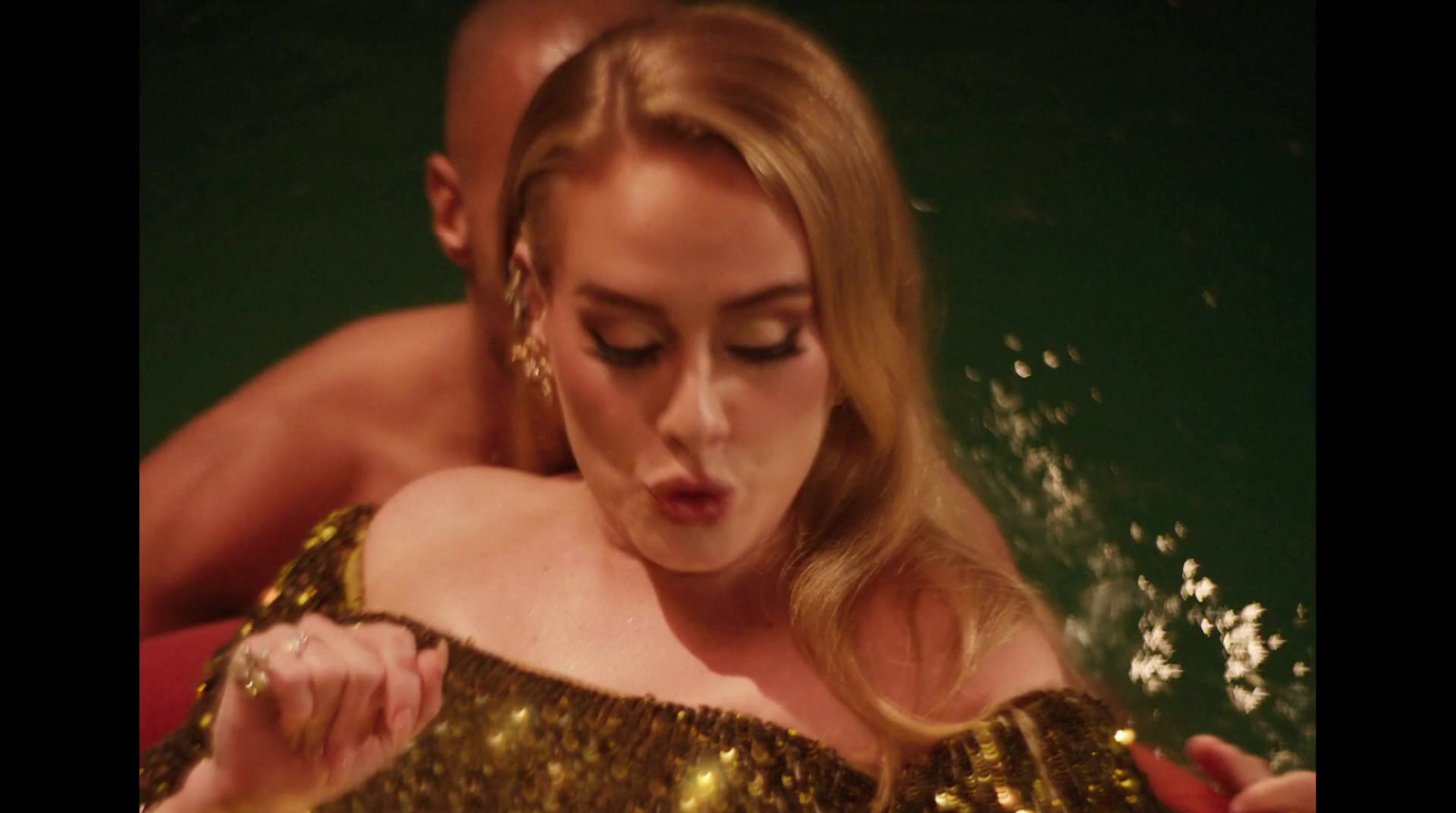 a woman in a gold dress in the water