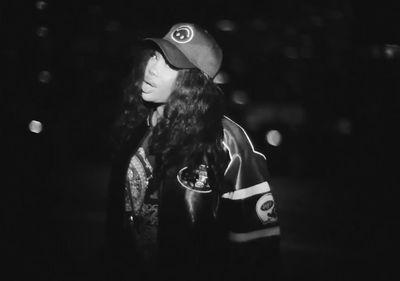 a black and white photo of a woman wearing a hat