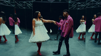 a man and a woman standing in front of a mirror